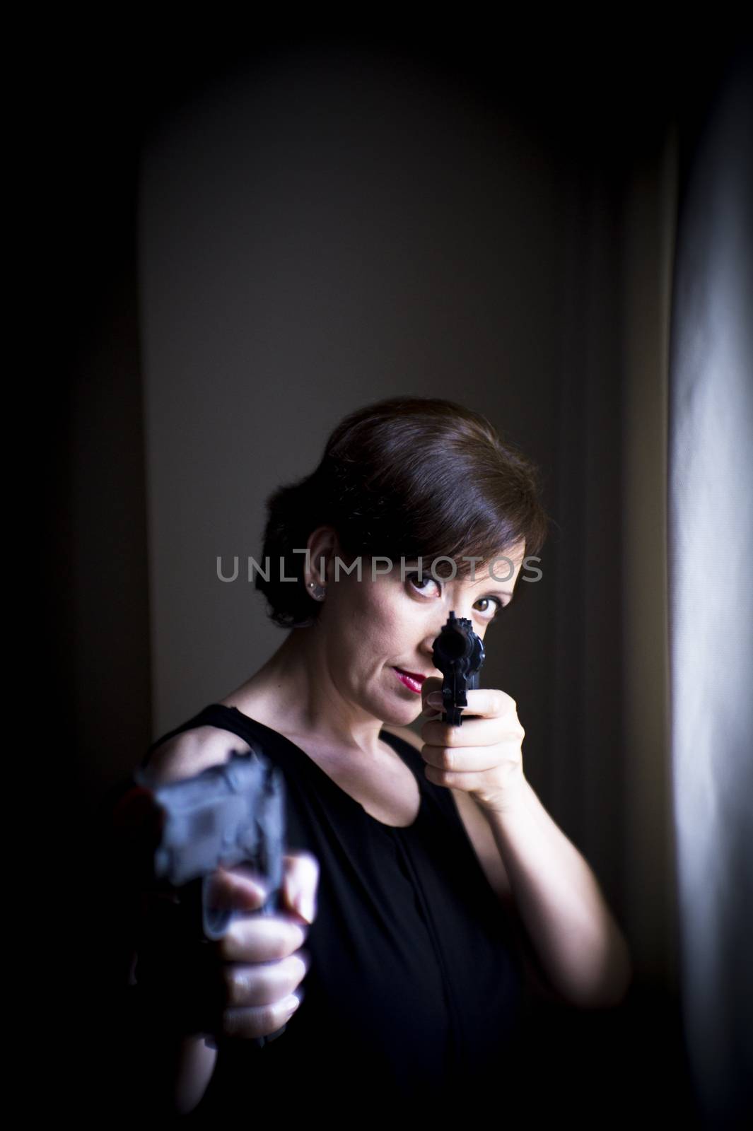 Portrait of woman with gun. Black dress