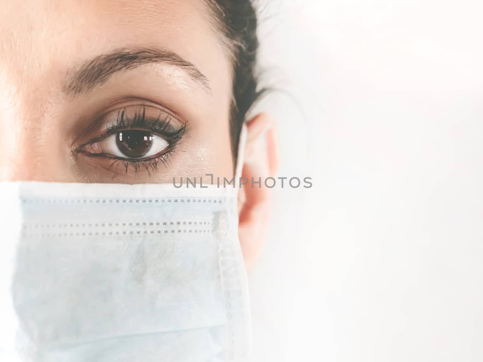 Half-faced portrait of a female doctor in the protective mask. Doctor in a medical mask. Patient, nurse. Protection against coronovirus COVID-19. Copy space.