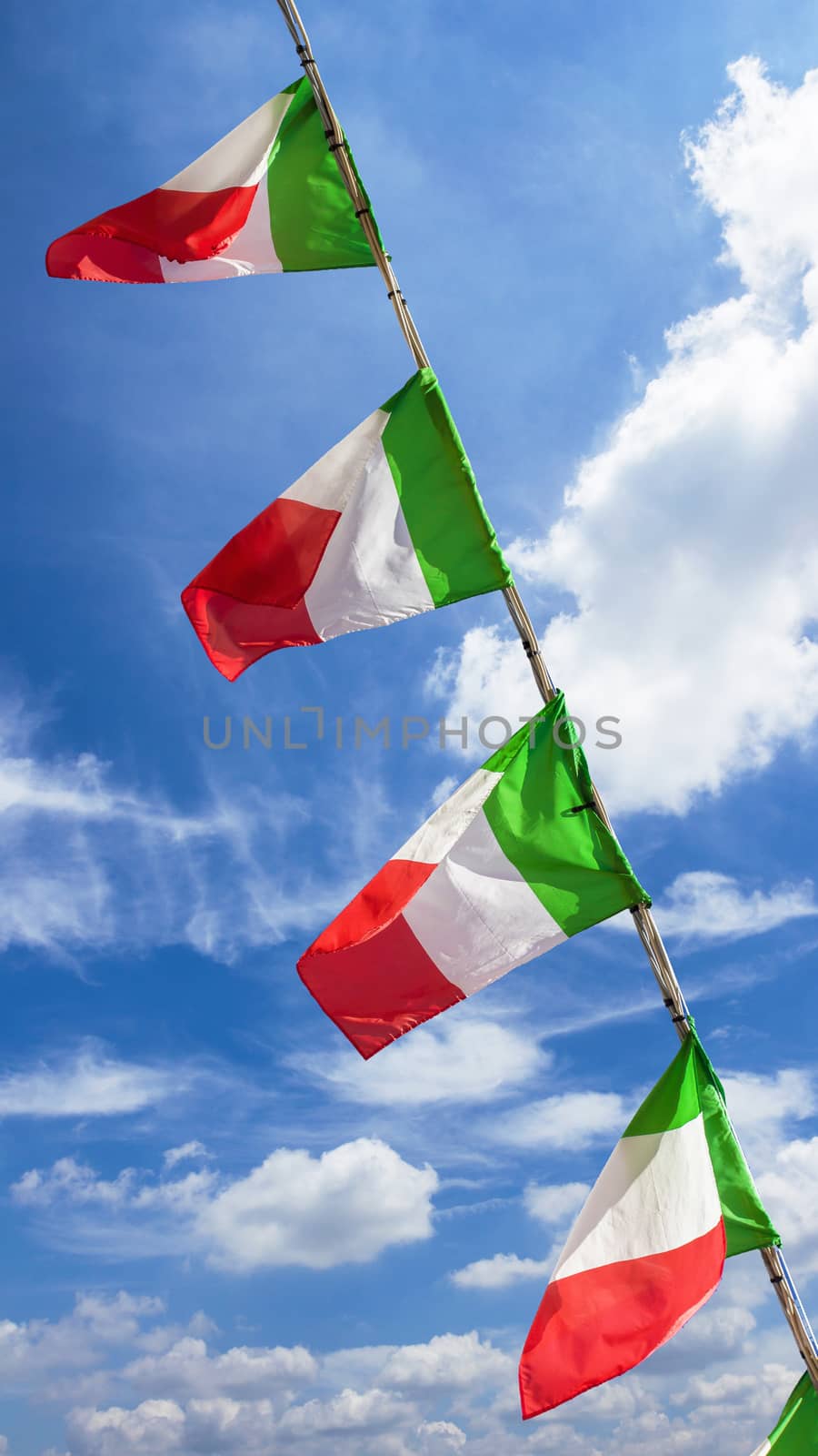 Small italian flags waving in the wind against blue sky