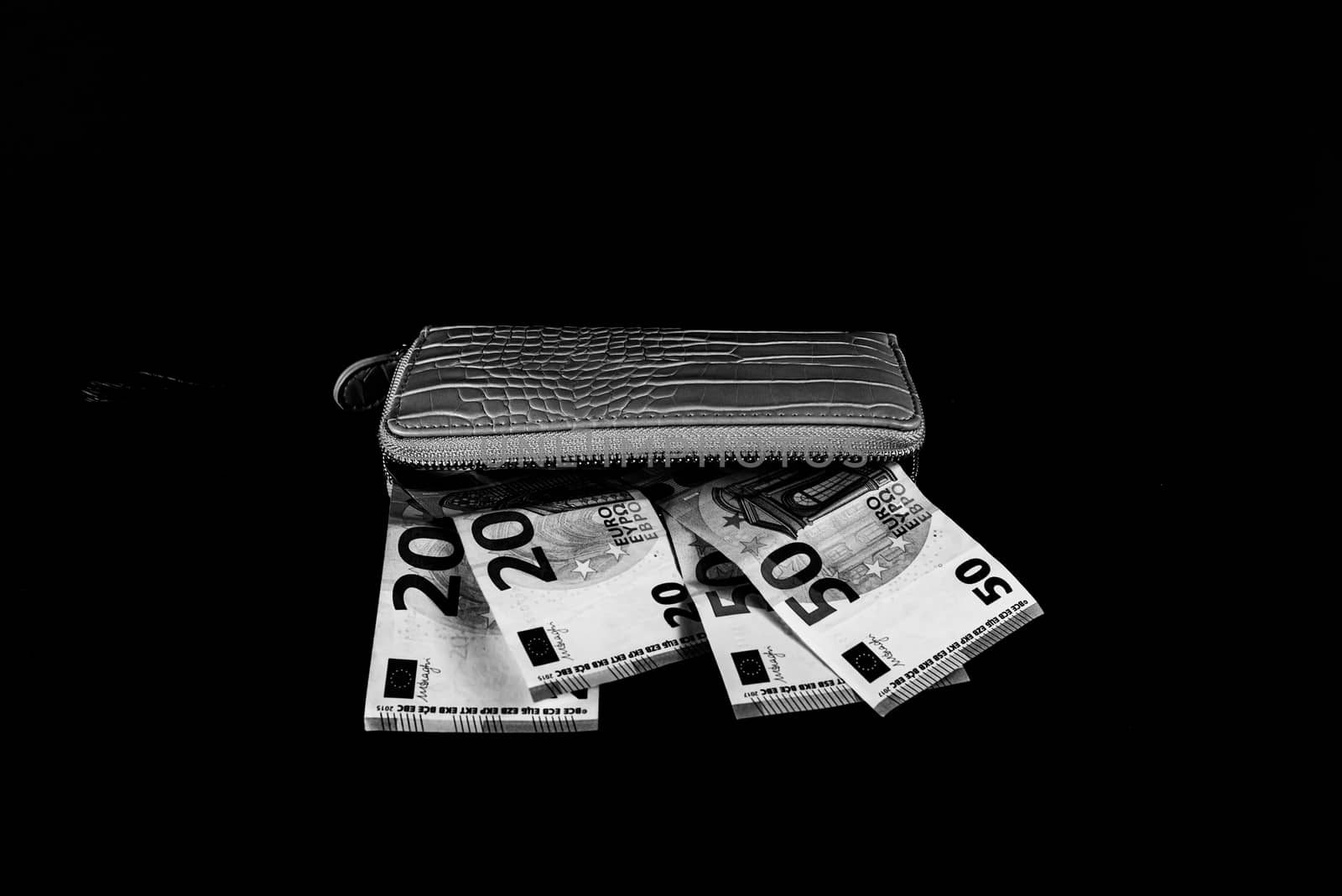 women's wallet on top of banknotes of different currency