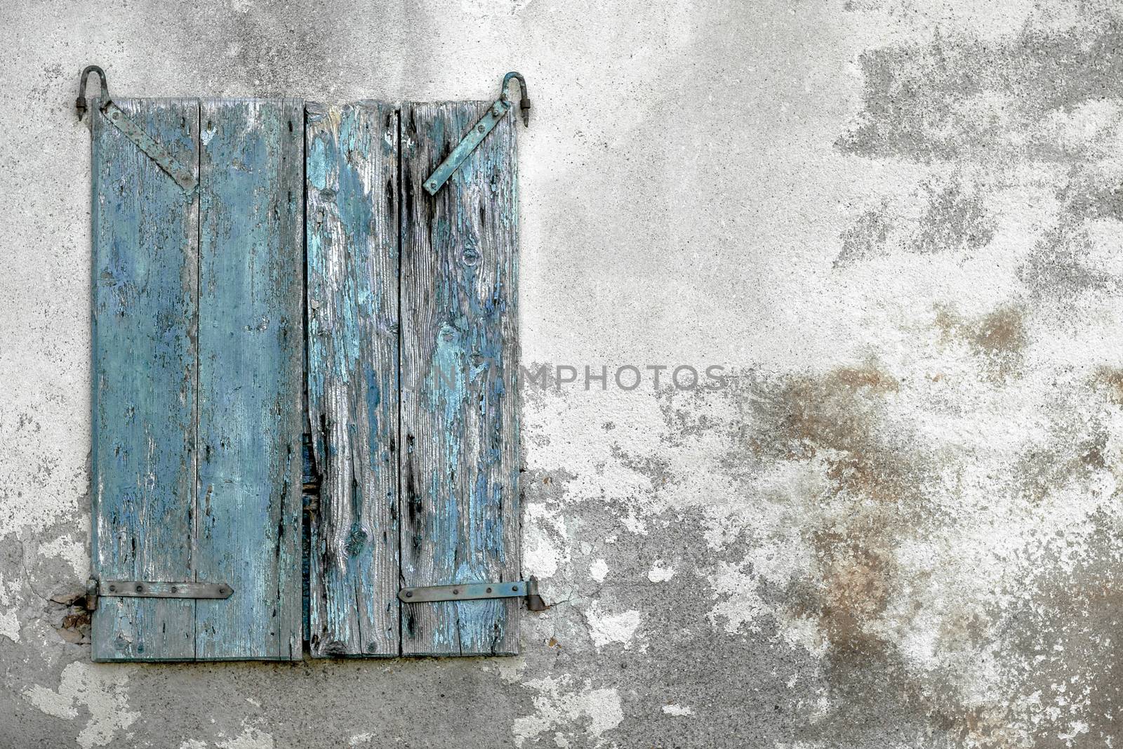 Old shabby stone wall with grungy wooden window. Space for text.