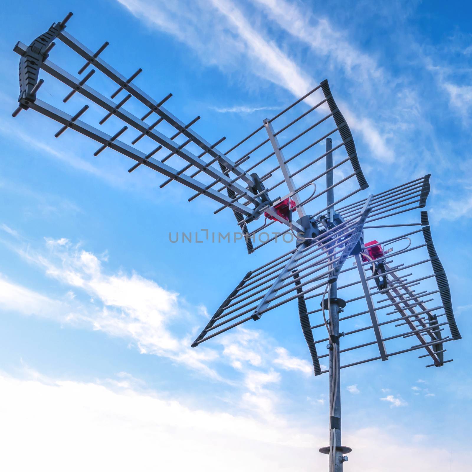 Television antenna with blue sky background. Directional antenna for reception of digital television broadcasting DVB-T and DVB-T2 against a blue sky.