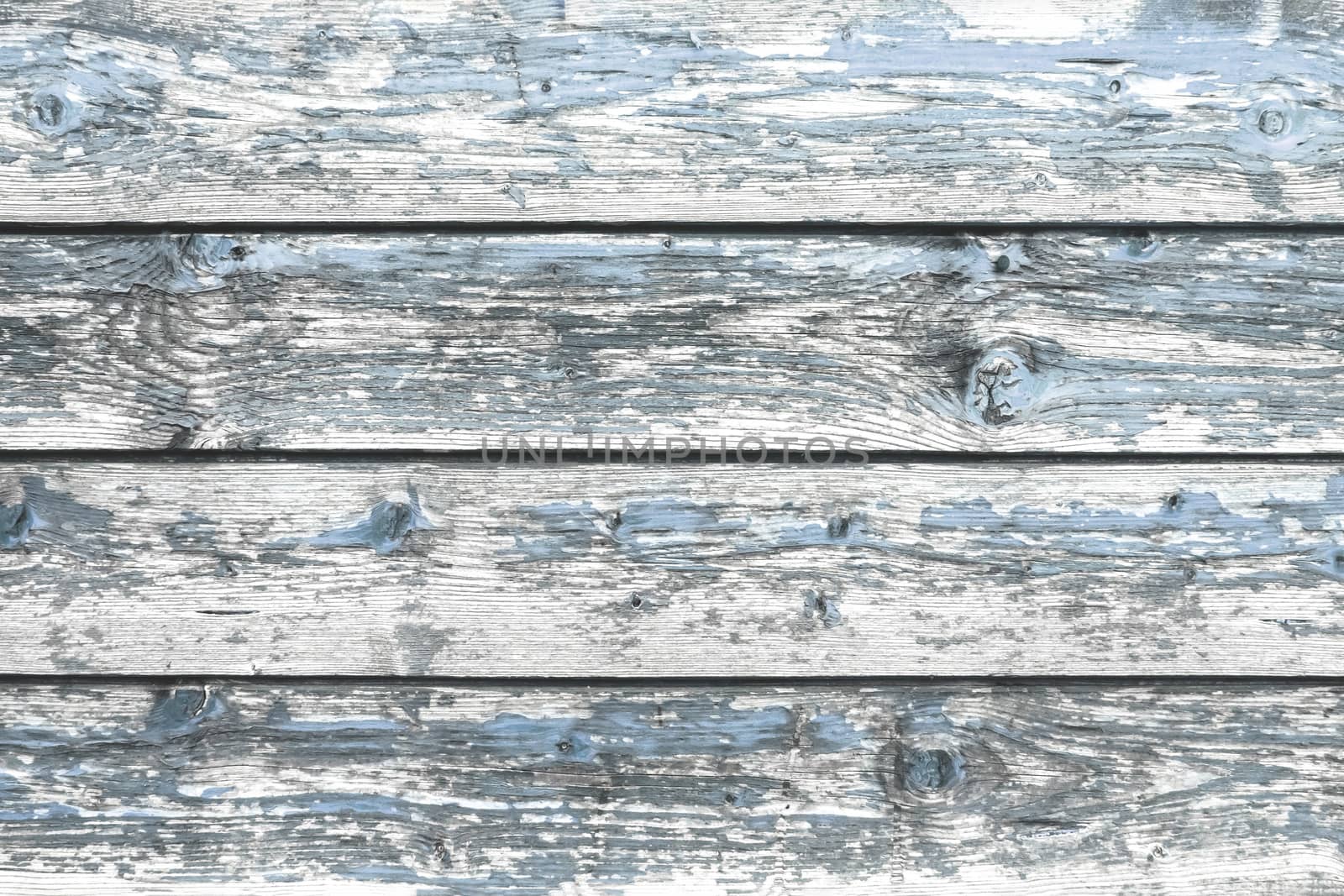 Color-Peel wood texture. Battered faded old light blue painted wooden boards with peeling. Wooden abstract background, texture.