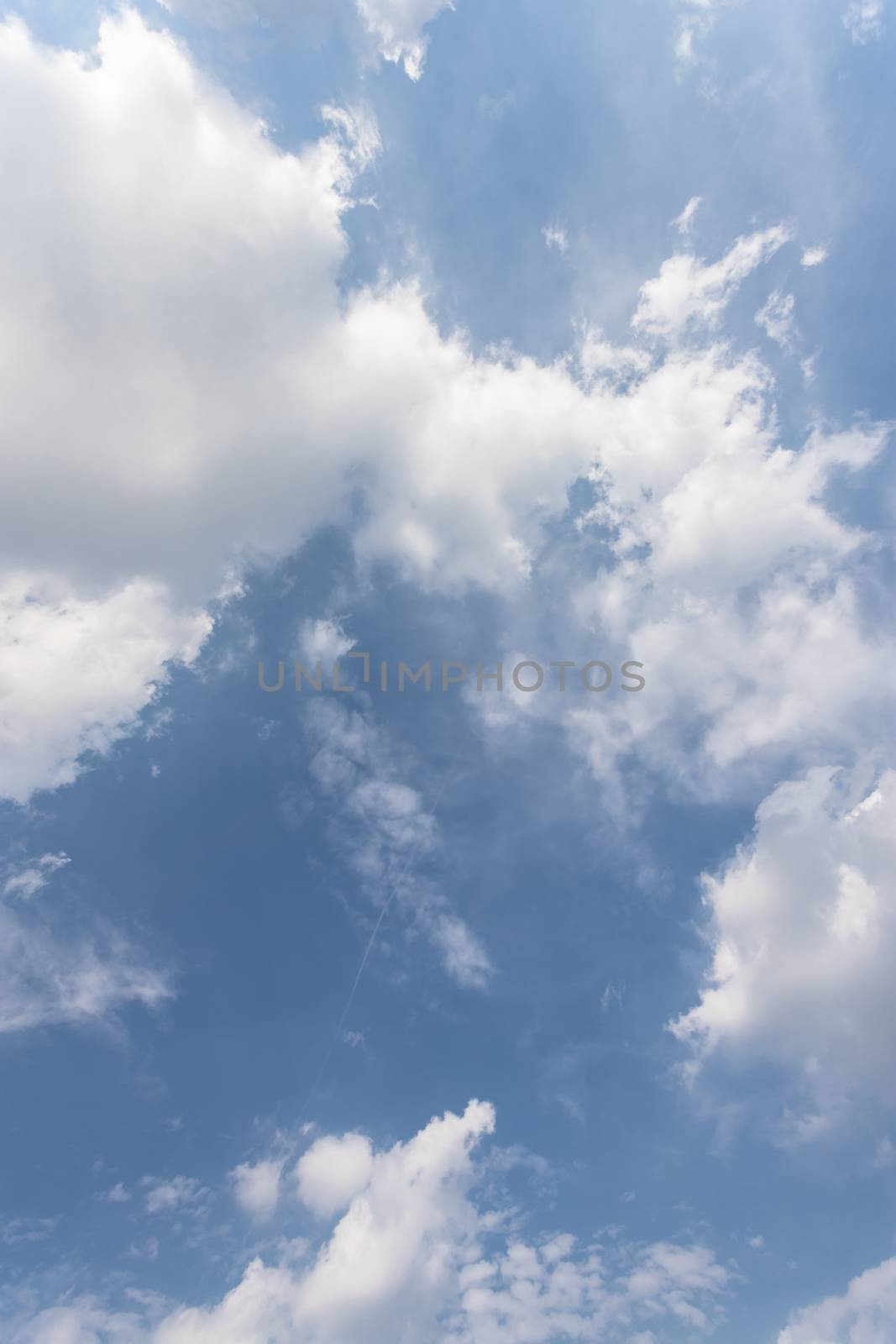 Blue sky dotted with white clouds, like cotton. Concepts of global warming, weather, nature.