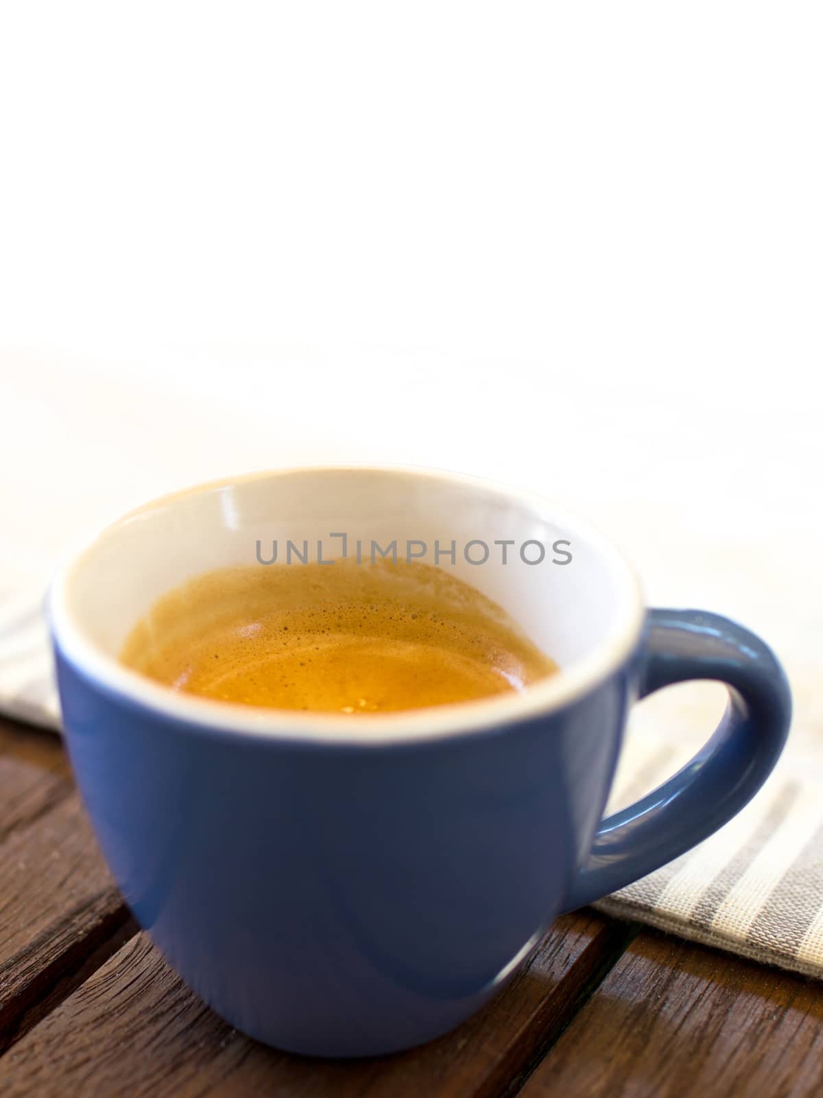 Cup of coffee on wooden table and white background for copy space.