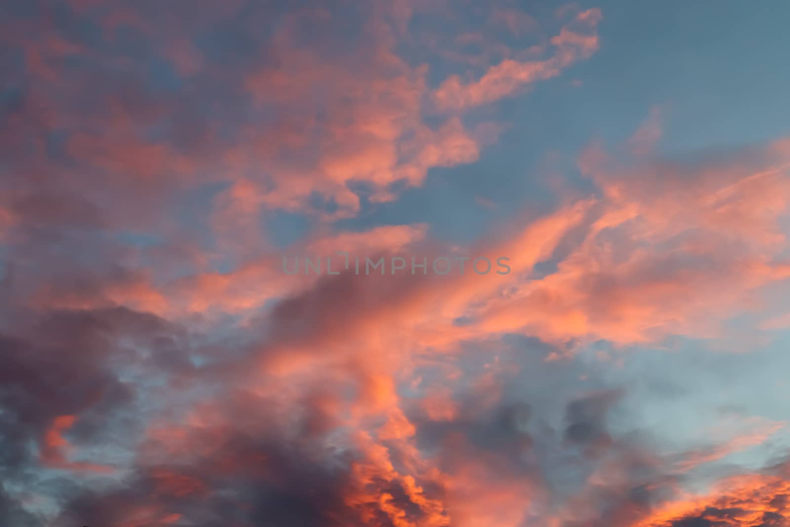 Beautiful panorama of orange and yellow clouds at sunrise and sunset in a blue sky