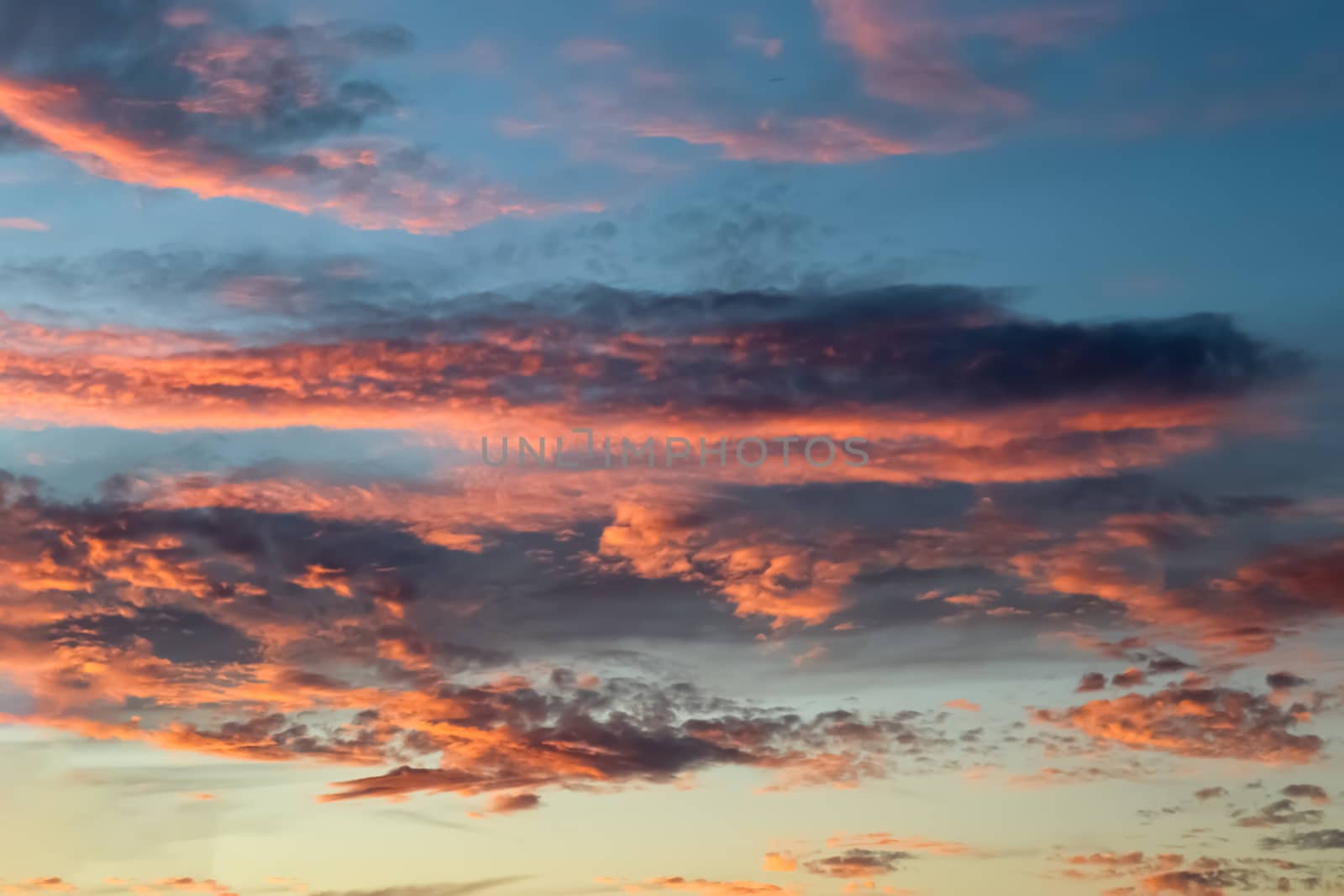 Beautiful panorama of orange and yellow clouds at sunrise and sunset in a blue sky