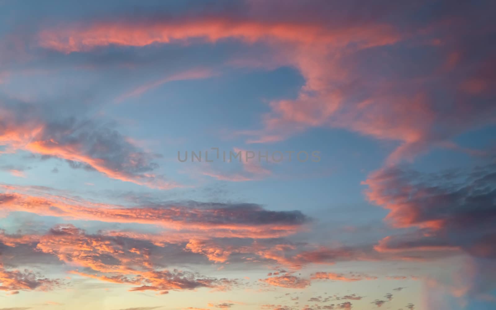 Beautiful panorama of orange and yellow clouds at sunrise and sunset in a blue sky