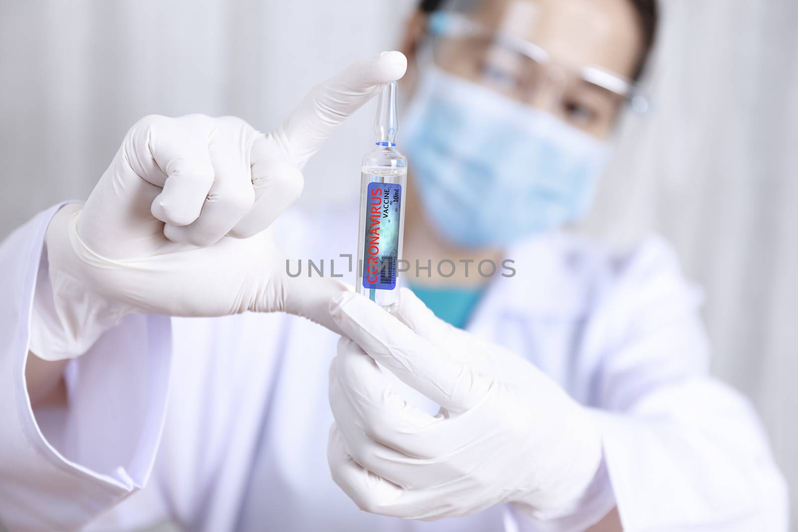 Covid-19 coronavirus vaccine. Close up hands of scientist show Covid-19 vaccine in glass vial. Hands of doctor wear latex glove holding Covid-19 vaccine in glass vial. Healthcare and medical concept.