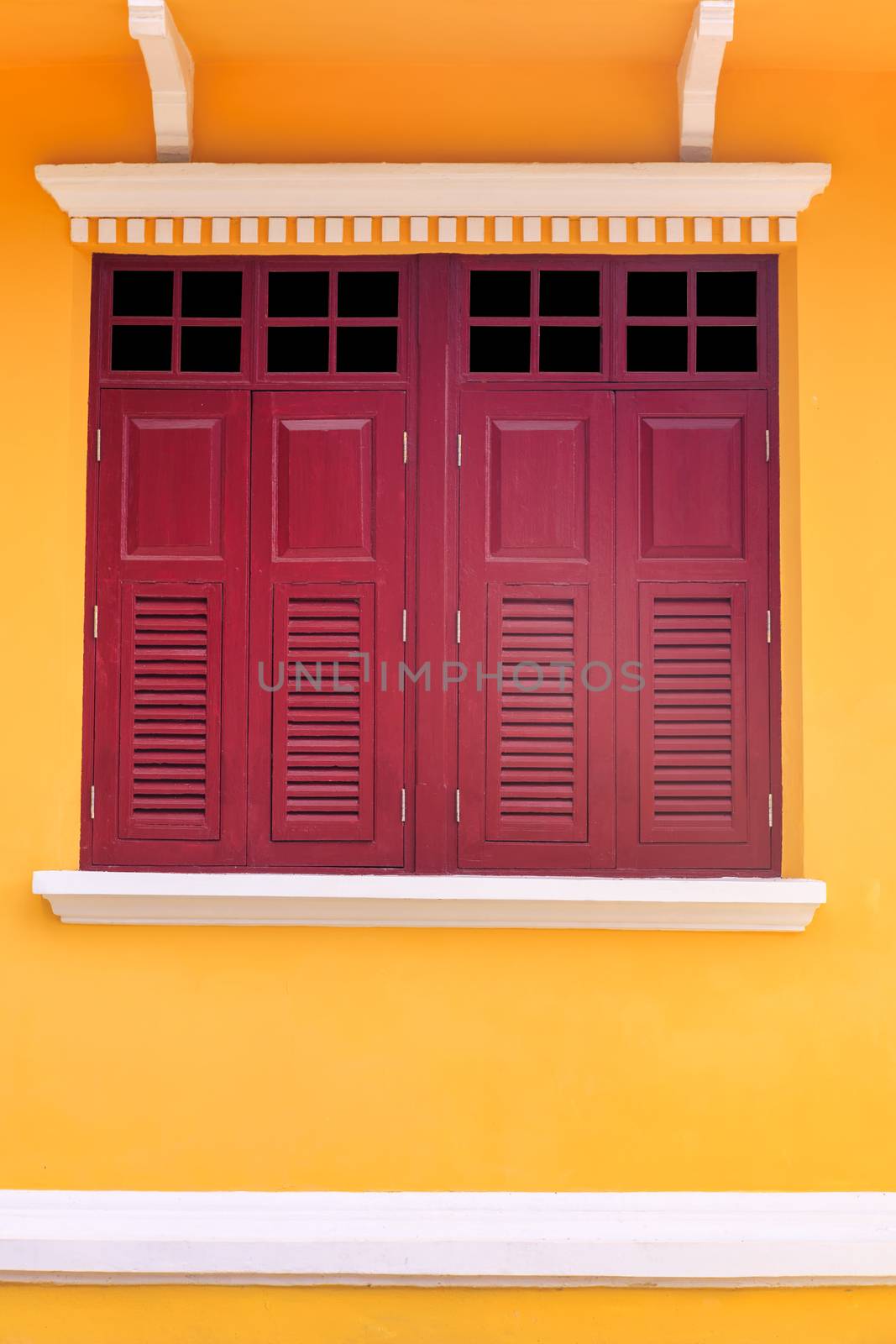 Old twin wood windows with yellow wall background. Old style double wood windows.
