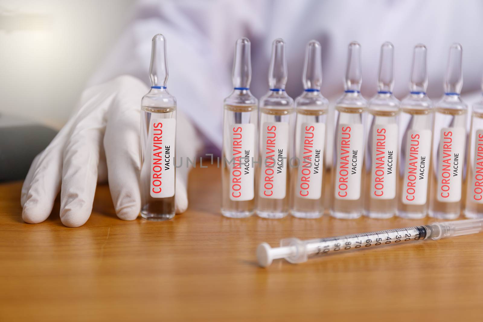 Covid-19 coronavirus vaccine. Close up hands of scientist show Covid-19 vaccine in glass vial. Hands of doctor wear latex glove holding Covid-19 vaccine in glass vial. with syring Healthcare and medical concept.