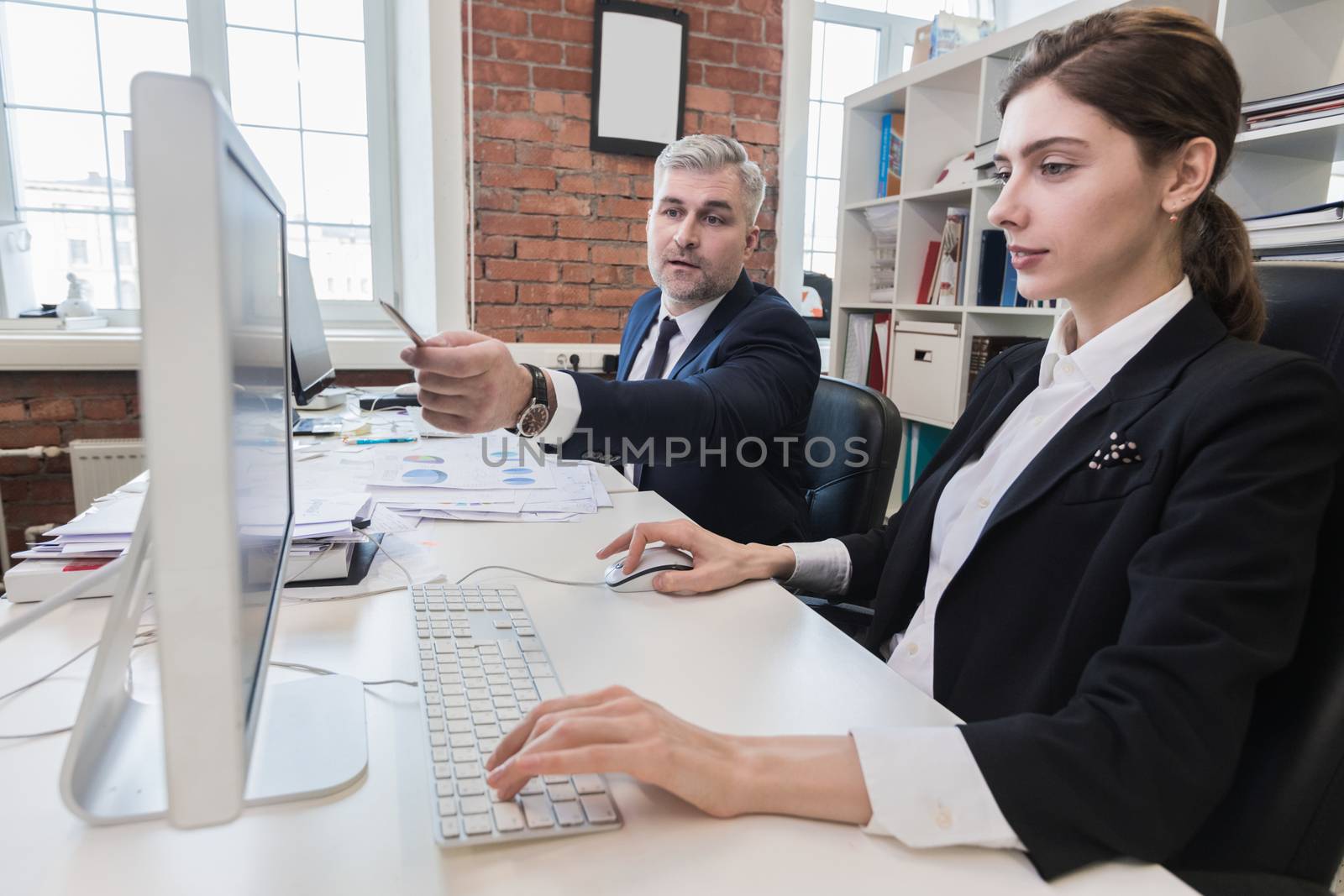 Business people working at office together, financial data, statistics, paperwork, Man pointing at computer monitor