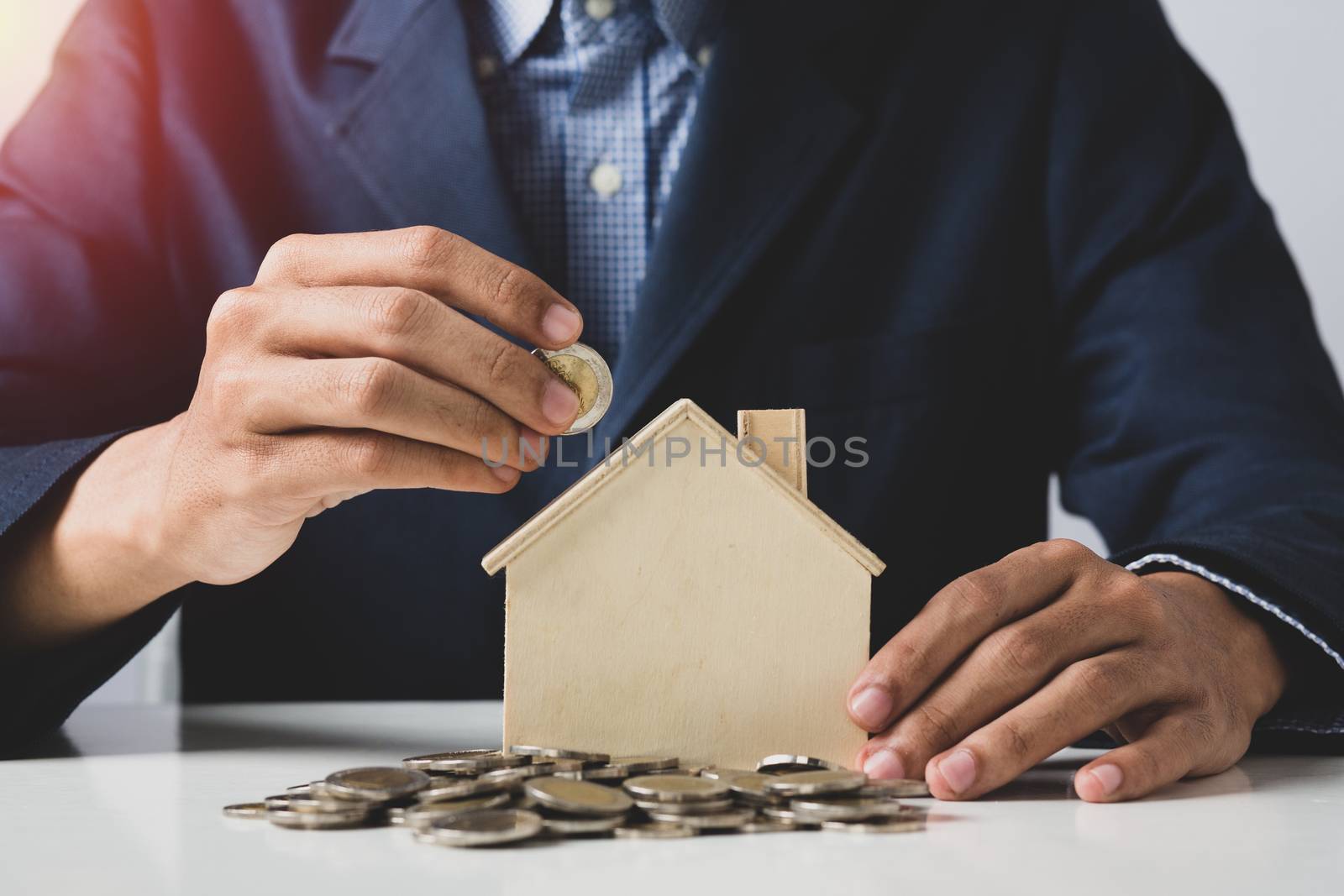 Hand of Business man holding coin put in piggy bank with money s by golfmhee