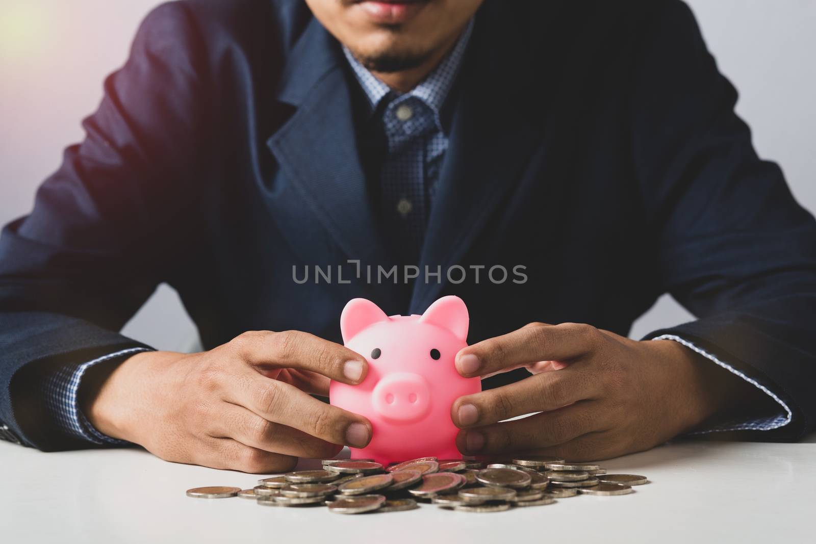 Hand of Business man holding coin put in piggy bank with money stack growing growth saving money, Concept invesment for financial freedom plan, business deposit to hope success