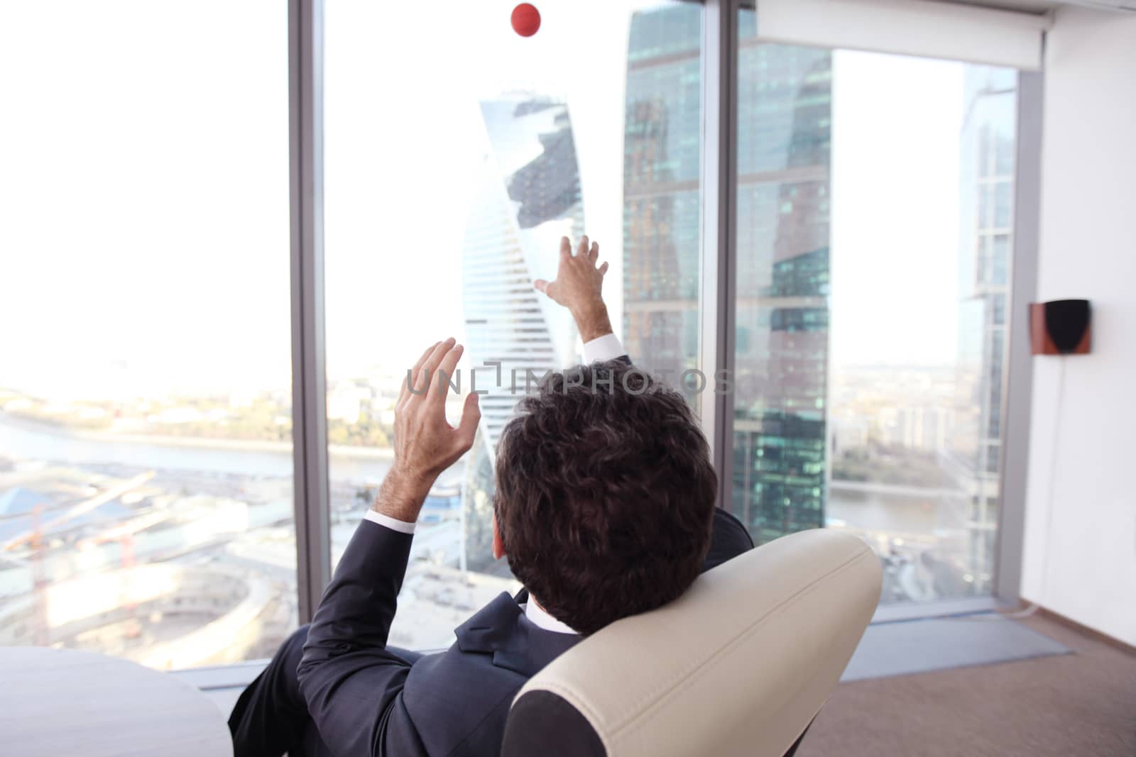 Business man playing with a basketball at the office