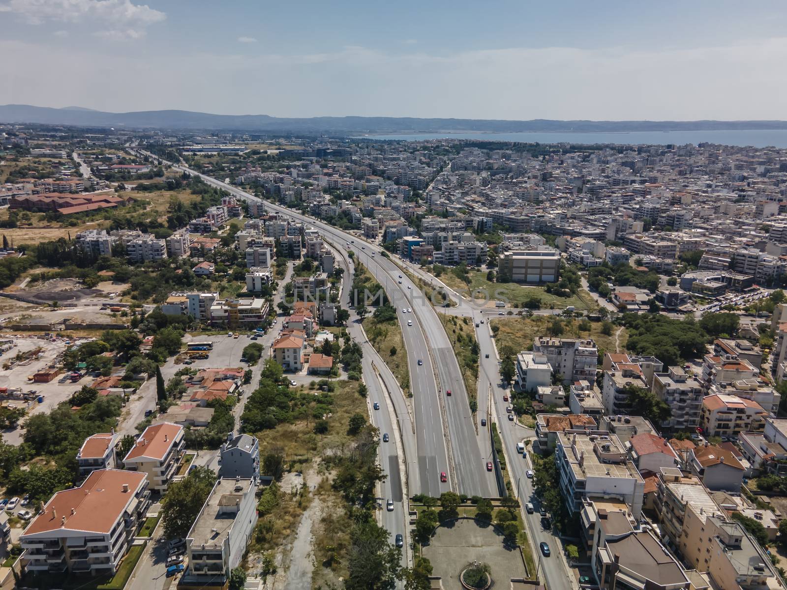 Day top panorama of European city with main highway & passing cars through residential blocks of flats.
