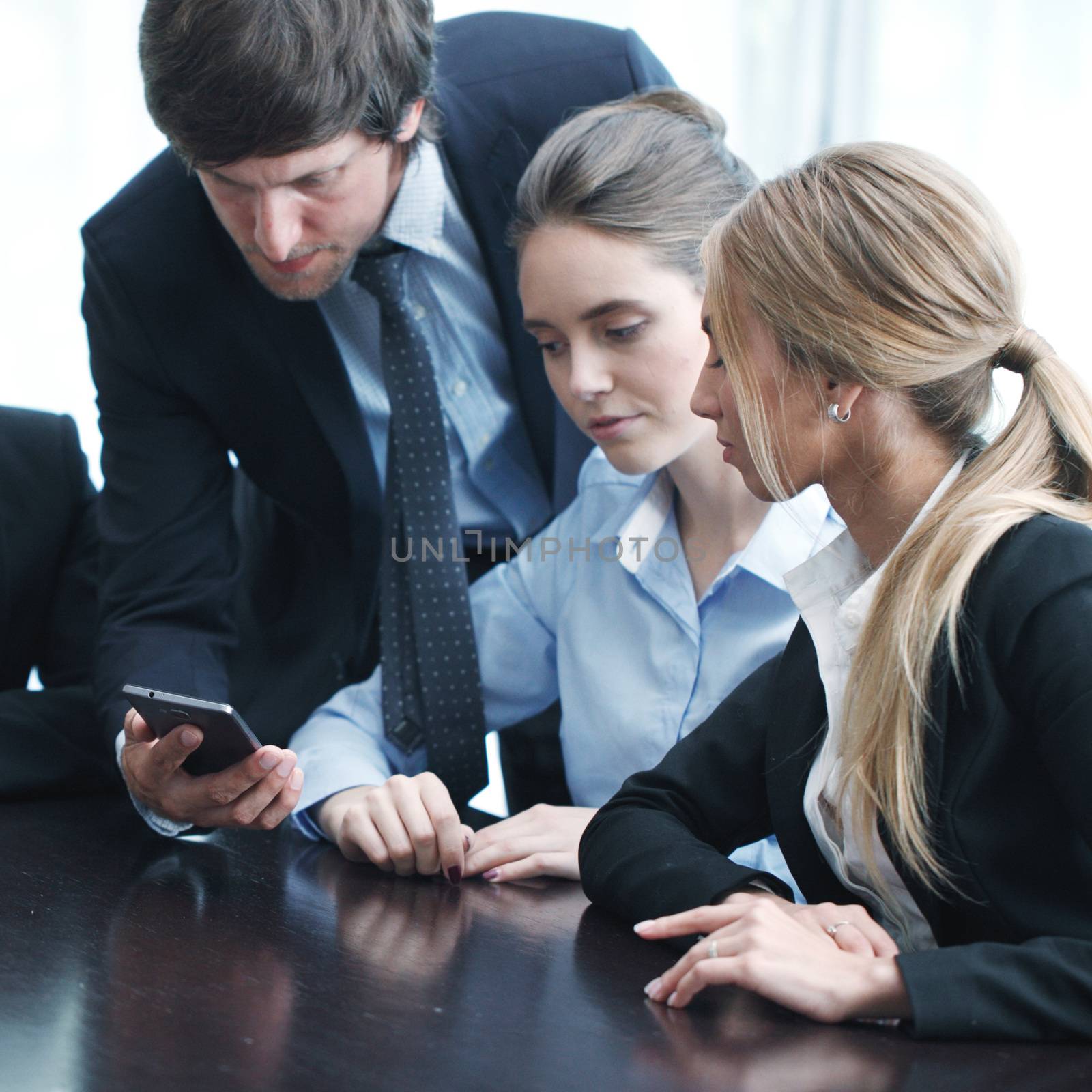 Group of business people working at office and using smartphone