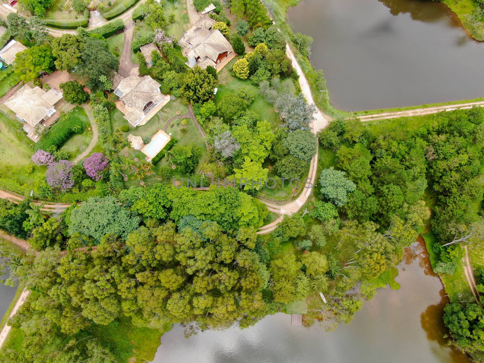 Aerial view of valley with lake, forest and villas in tropical country. Green mountain with forest on Brazil