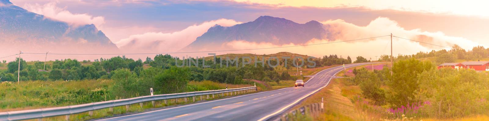 Empty winding country road in Norway, Europe, Scandinavia. Auto travel on sunset. Blue sky with clouds.