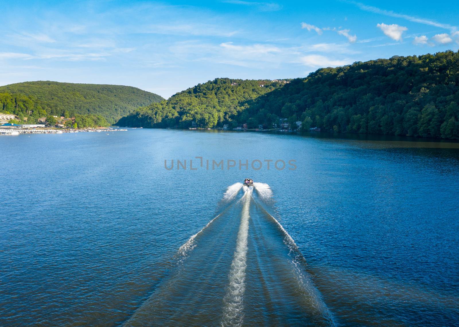 Speedboat sailing down Cheat Lake near Morgantown in West Virginia from aerial drone shot above the water
