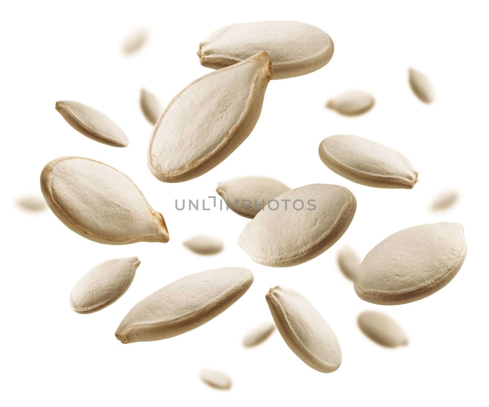 Pumpkin seeds levitate on a white background.
