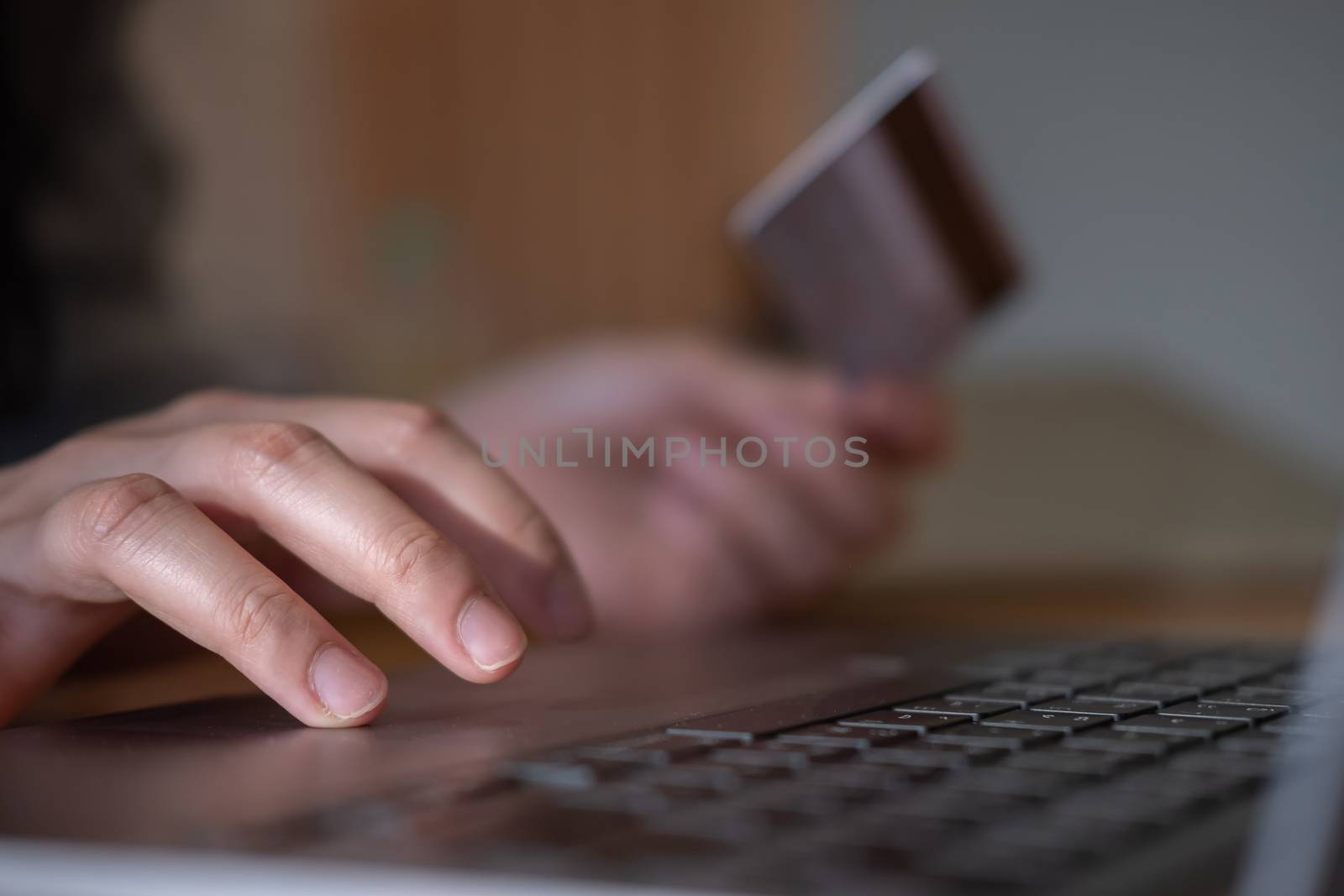 Close up hands holding credit card and using laptop. Online shopping by nateemee