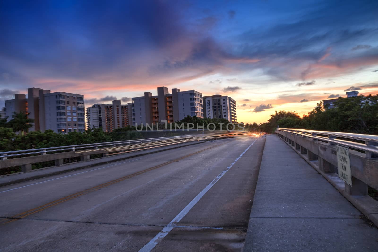 Light trails on the Overpass of Bluebill Avenue leading toward Delnor Wiggins State Park at sunset in Naples, Florida.