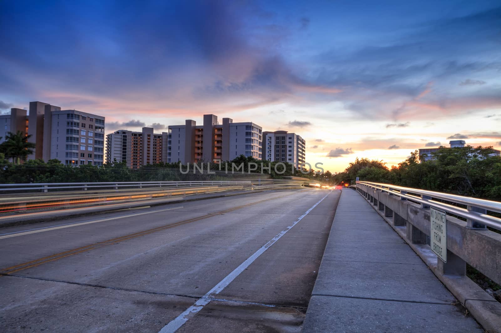 Light trails on the Overpass of Bluebill Avenue leading toward Delnor Wiggins State Park at sunset in Naples, Florida.