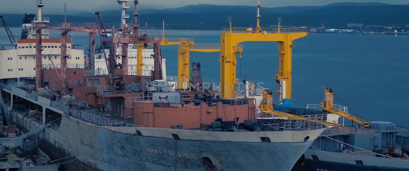 Auxiliary cargo ship in the industrial port.