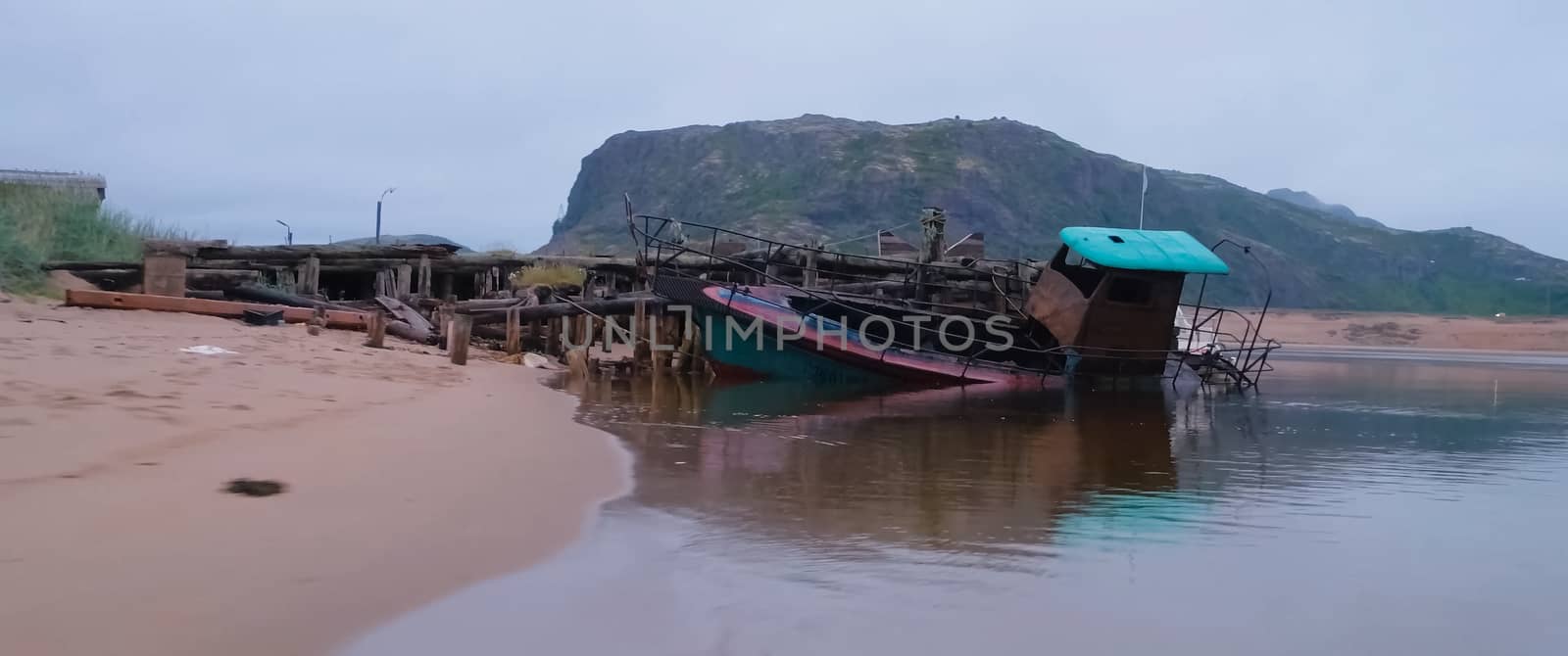 Rotten old wooden boat on shore. by DePo