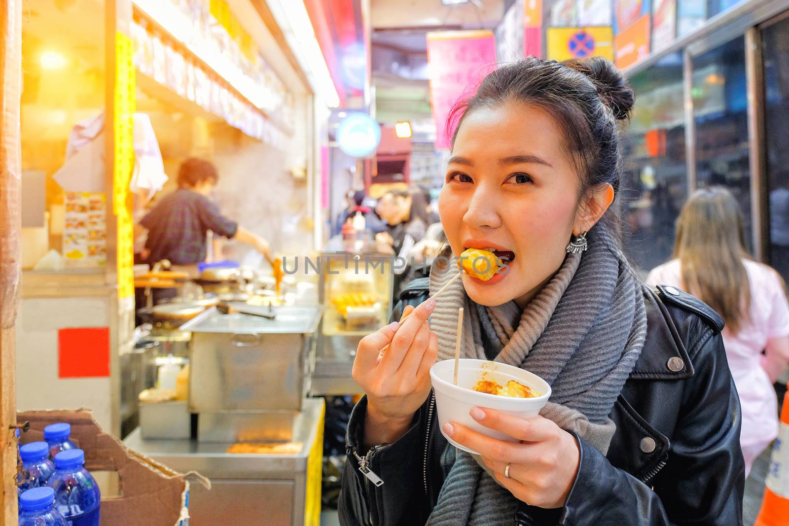 Chinese Asian young female model eating Chinese Steamed Dumpling on Street in Hong Kong
