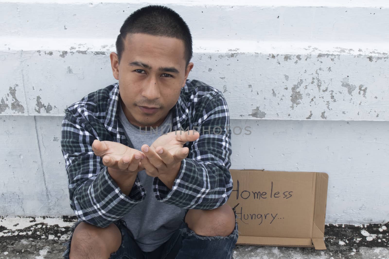 Unhappy homeless man sitting on overpass