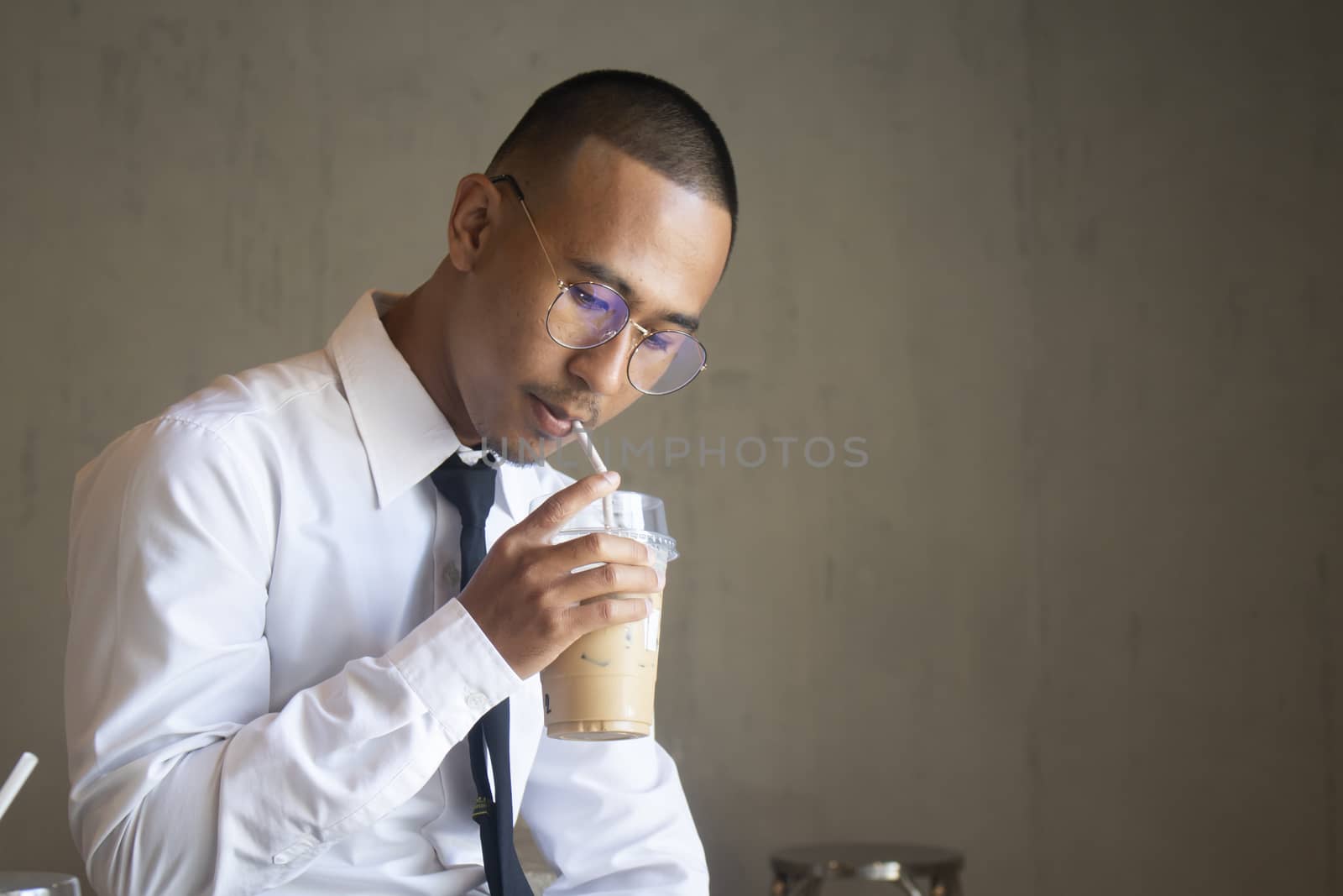 Asian business man drinking ice coffee in cafe by Gobba17