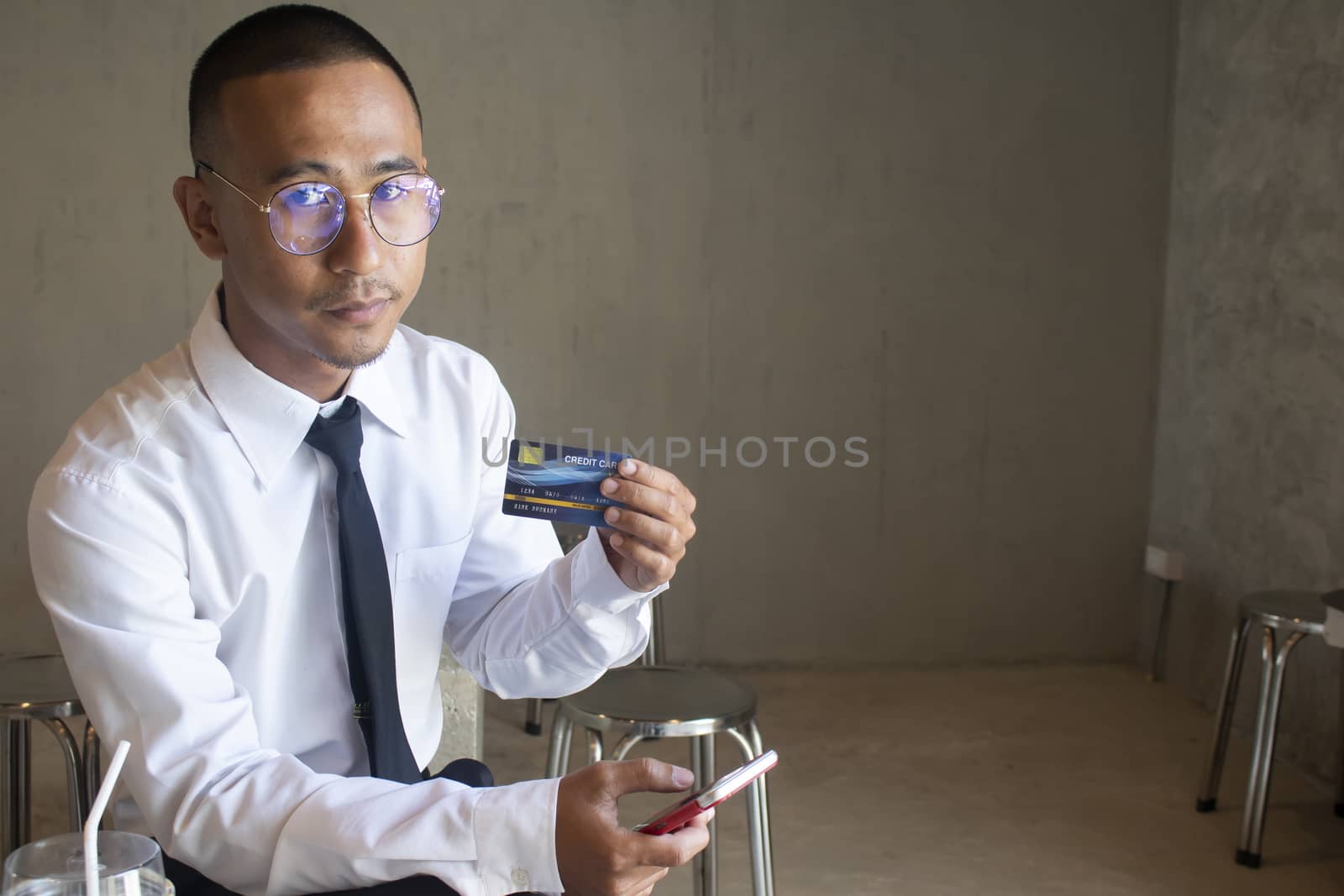 Asian business man using cradit card for shopping online with smart phone