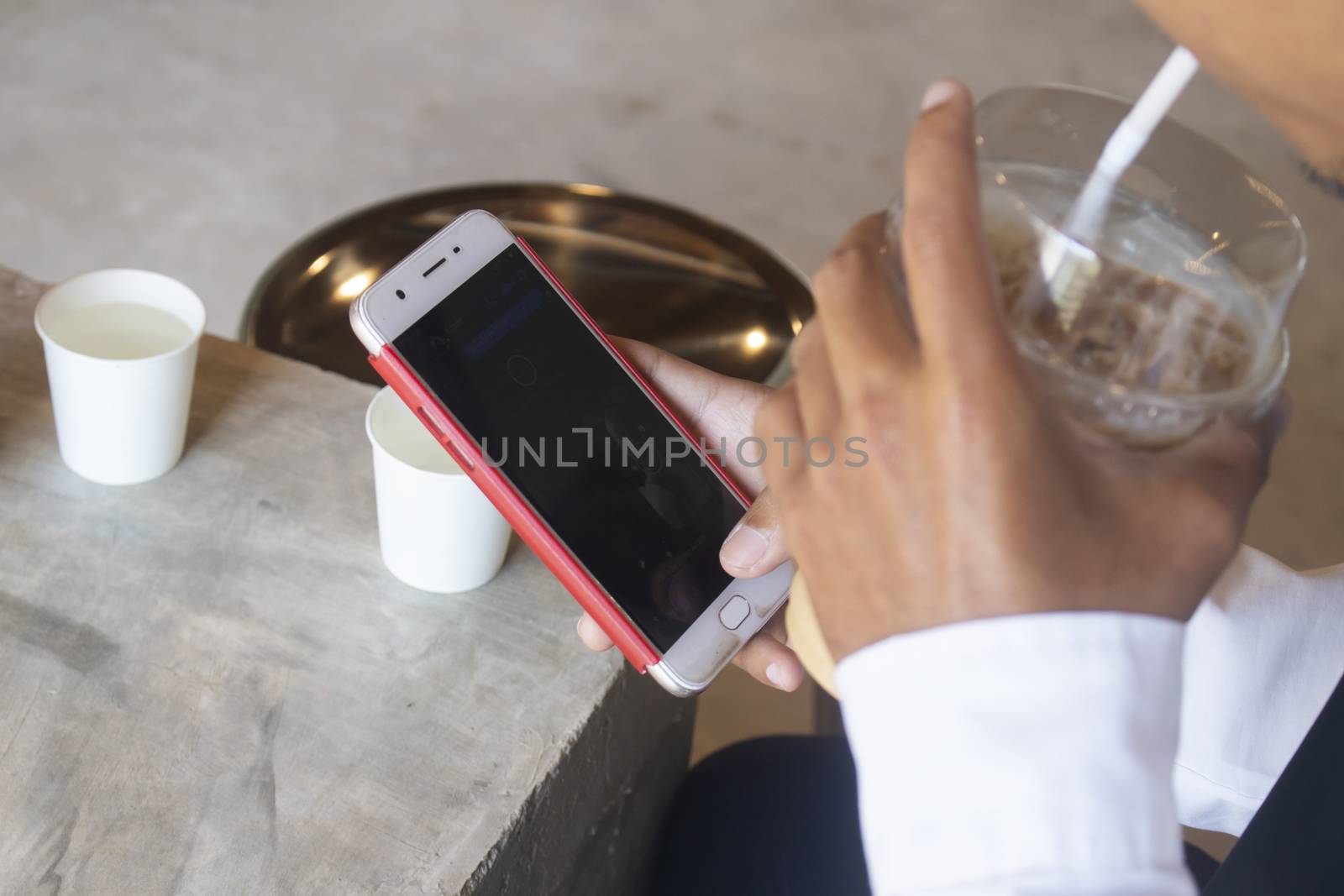 Closeup view of male hands touching mobile phone.