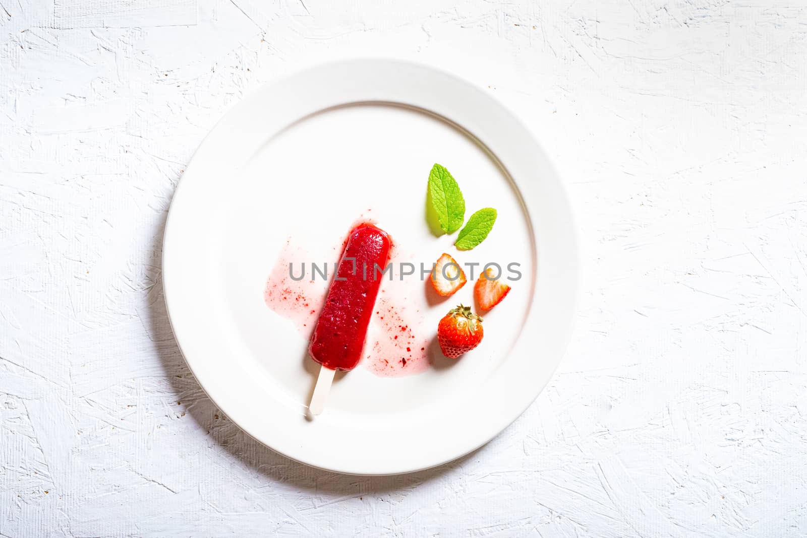 Delicious strawberry popsicles on light background