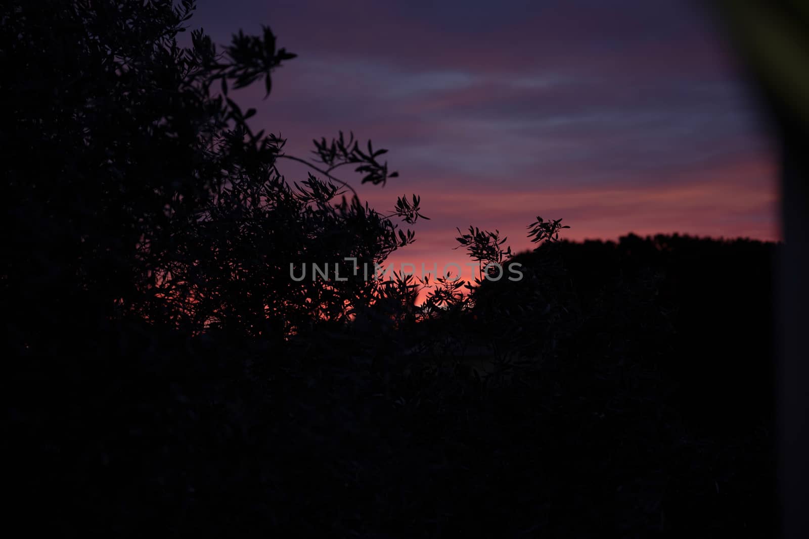 Early morning behind mountains, dark landscape, sunrise sky.