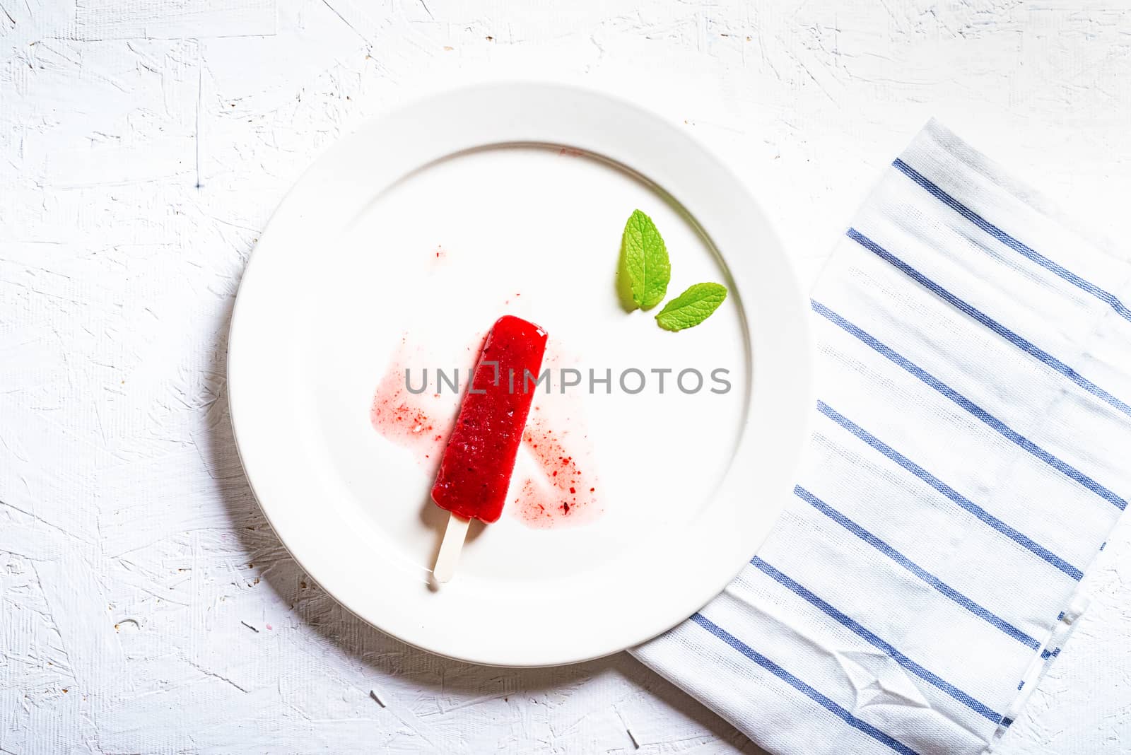 Delicious strawberry popsicles on light background