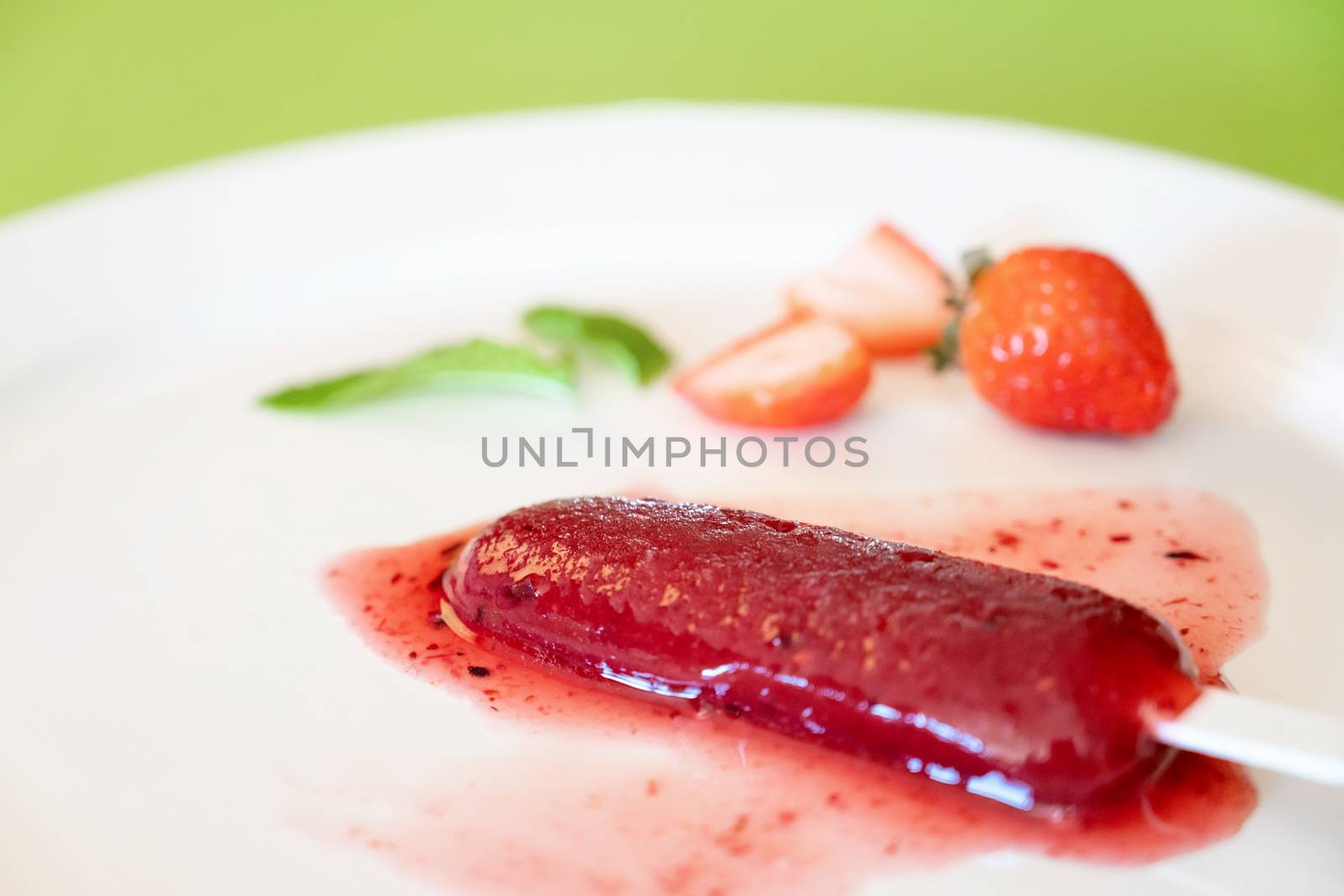 Delicious strawberry popsicles on light background
