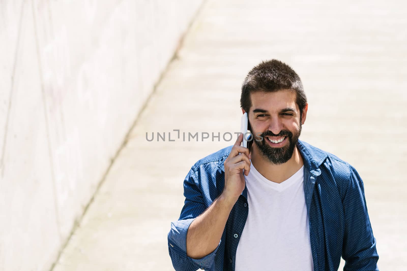 Portrait of a bearded man using his mobile.