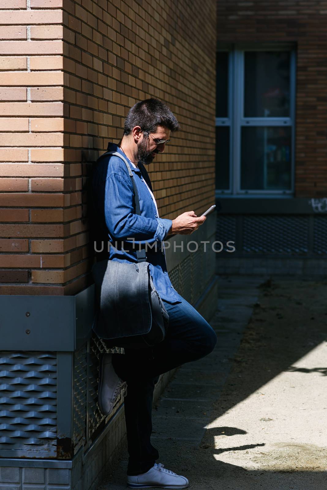 Portrait of handsome bearded man using his mobile. by raferto1973