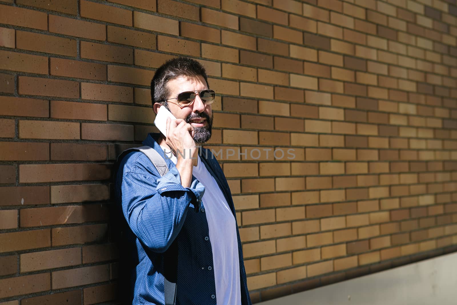 Portrait of a bearded man using his mobile.