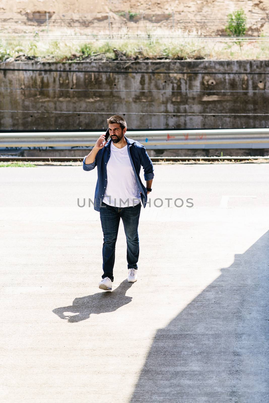 Portrait of a bearded man using his mobile.