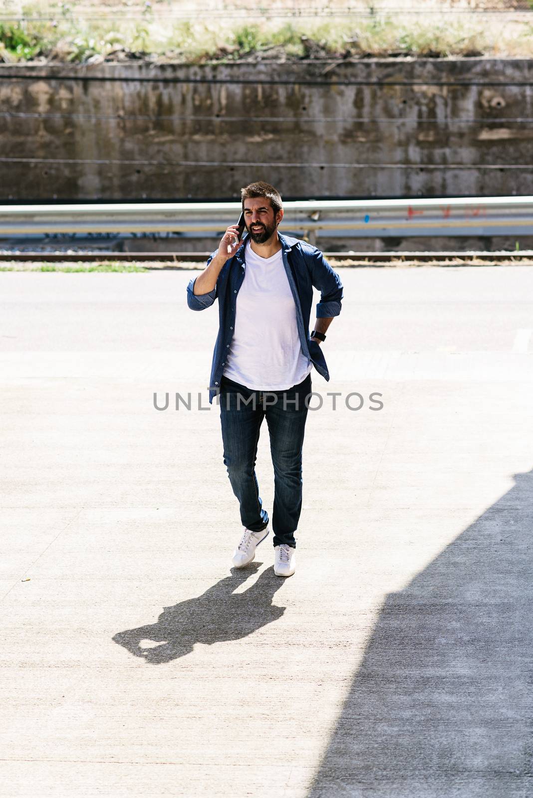 Portrait of a bearded man using his mobile.