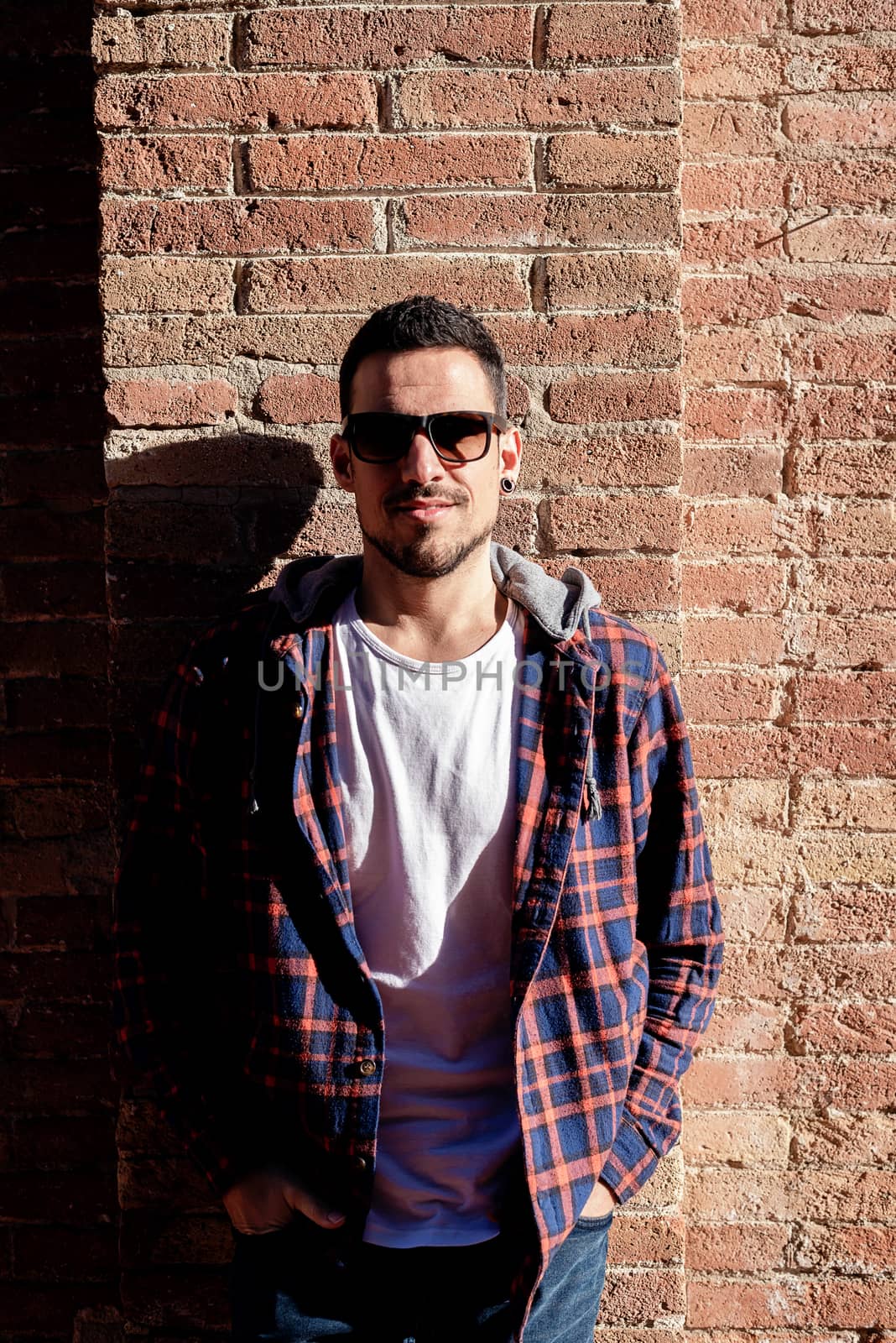 Portrait of relaxed casual male with sunglasses laughing.