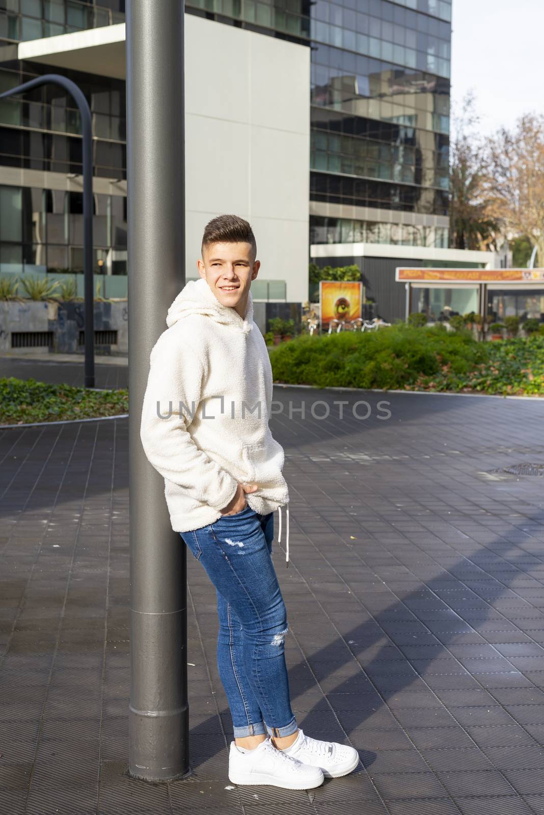 Portrait of young male with hands on pocket leaning on wall outdoors