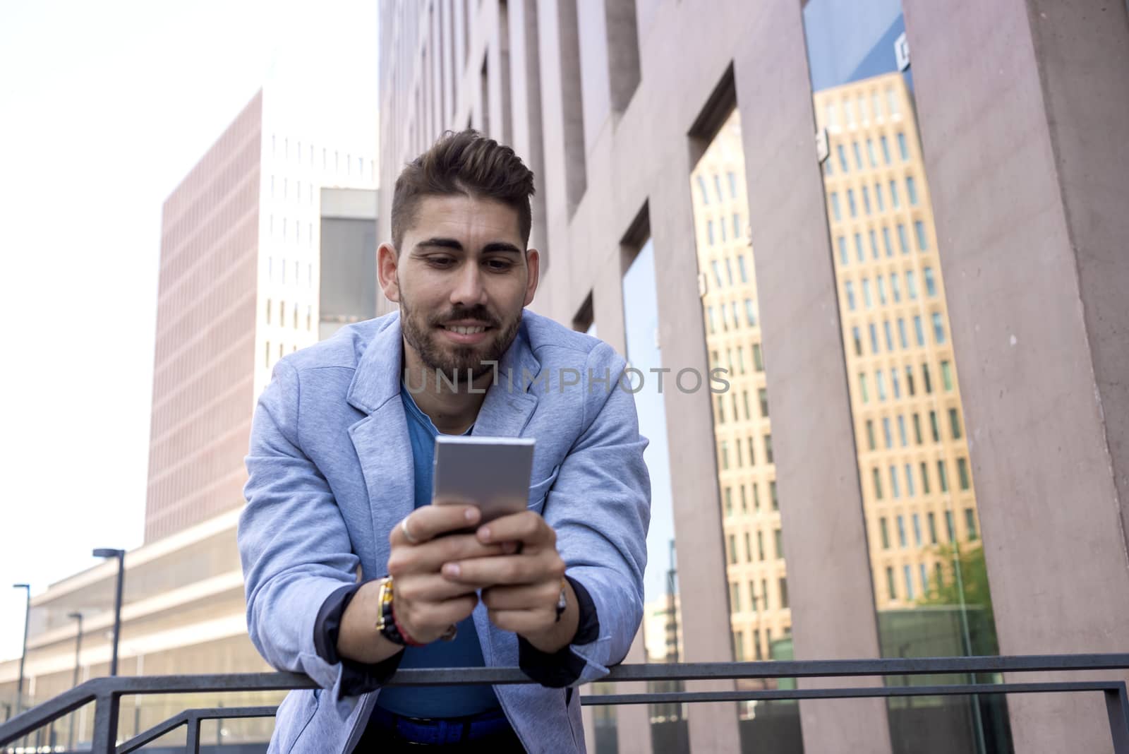 Portrait of Handsome young man smiling when he is using his mobile phone