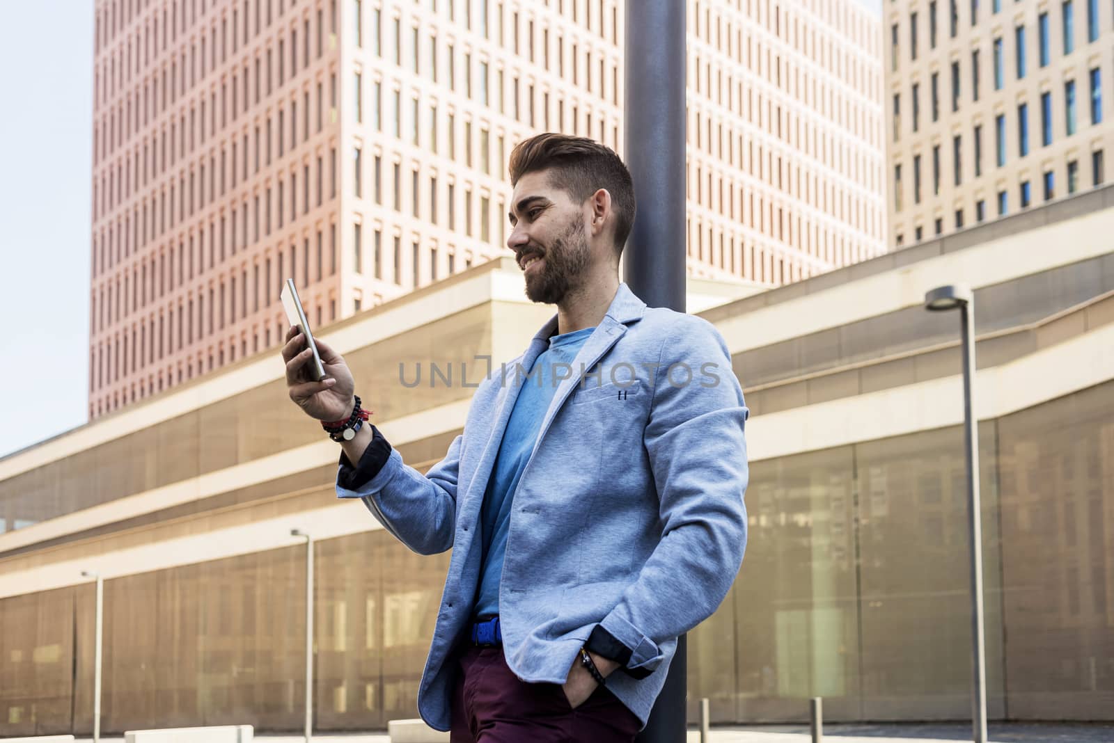 Portrait of Handsome young man smiling when he is using his mobile phone