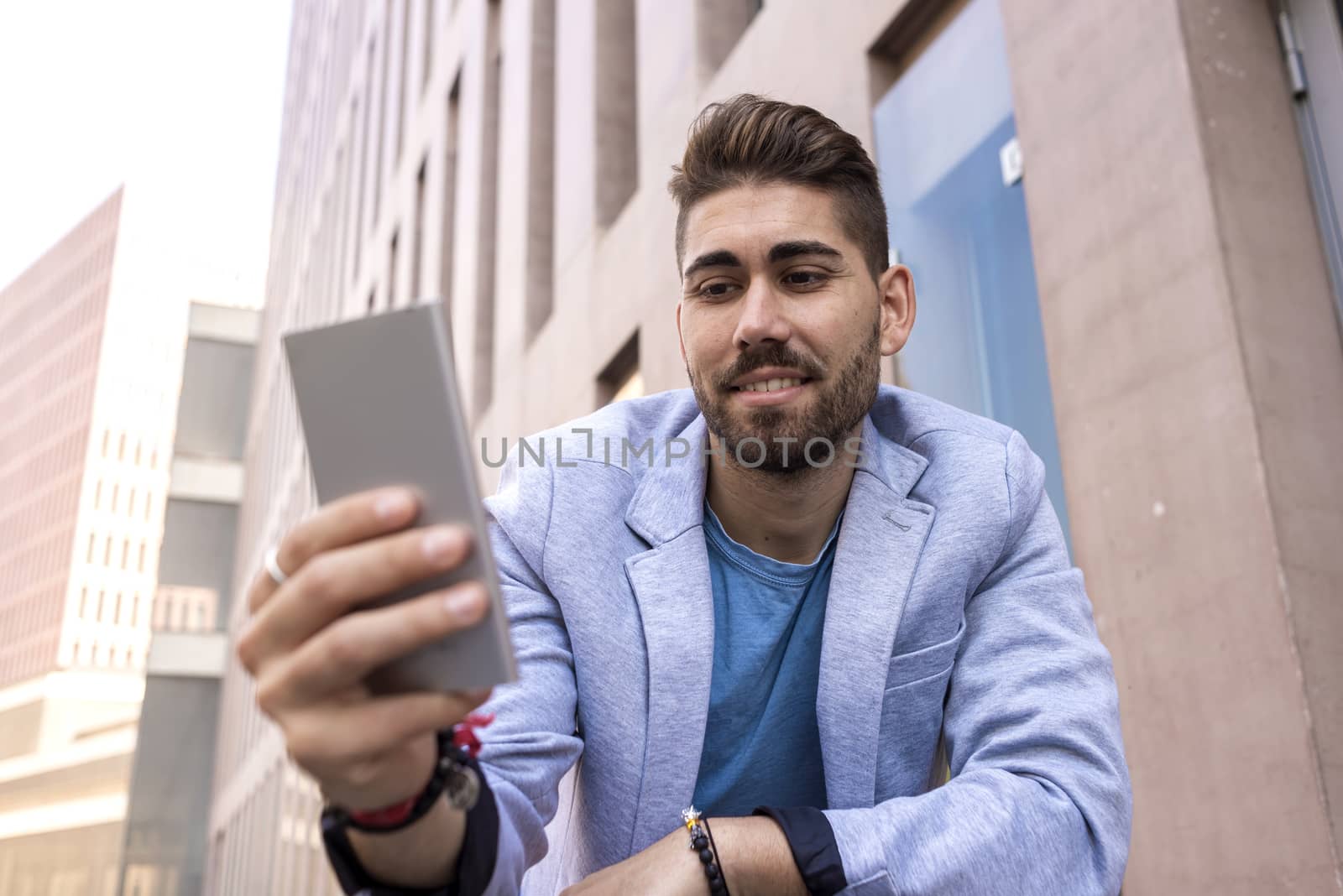 Portrait of Handsome young man smiling when he is using his mobile phone