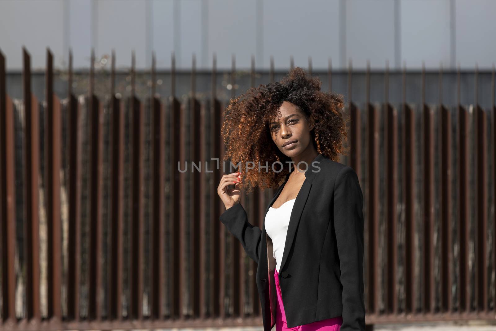 Portrait of a beautiful afro american woman standing in the street in a sunny day